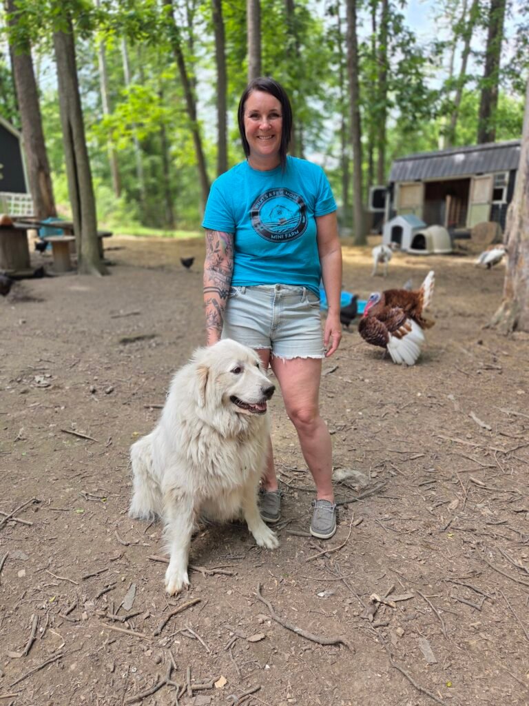 Cassie and her Great Pyrenees Grizzy, with a turkey, chicken and goats in the background. 